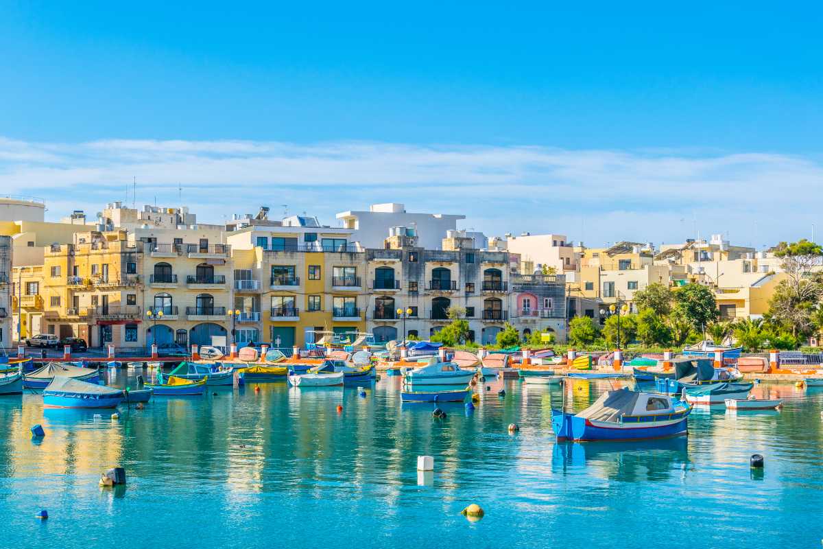 Vista del porto di Ischia con traghetti in arrivo, valigie e turisti, atmosfera rilassata
